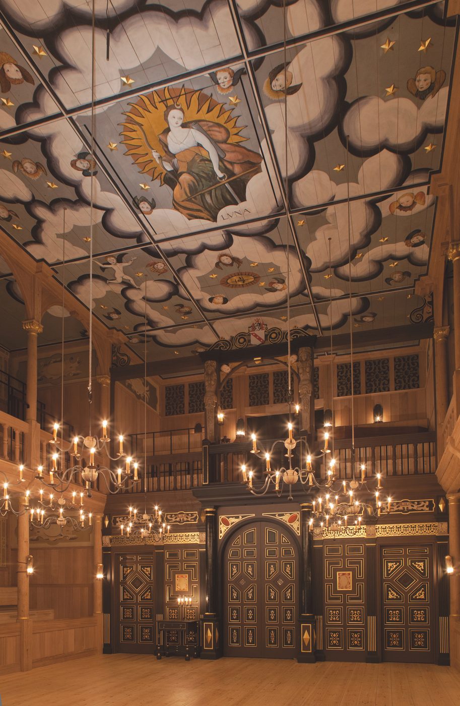 A tall ceilinged theatre with candelabras