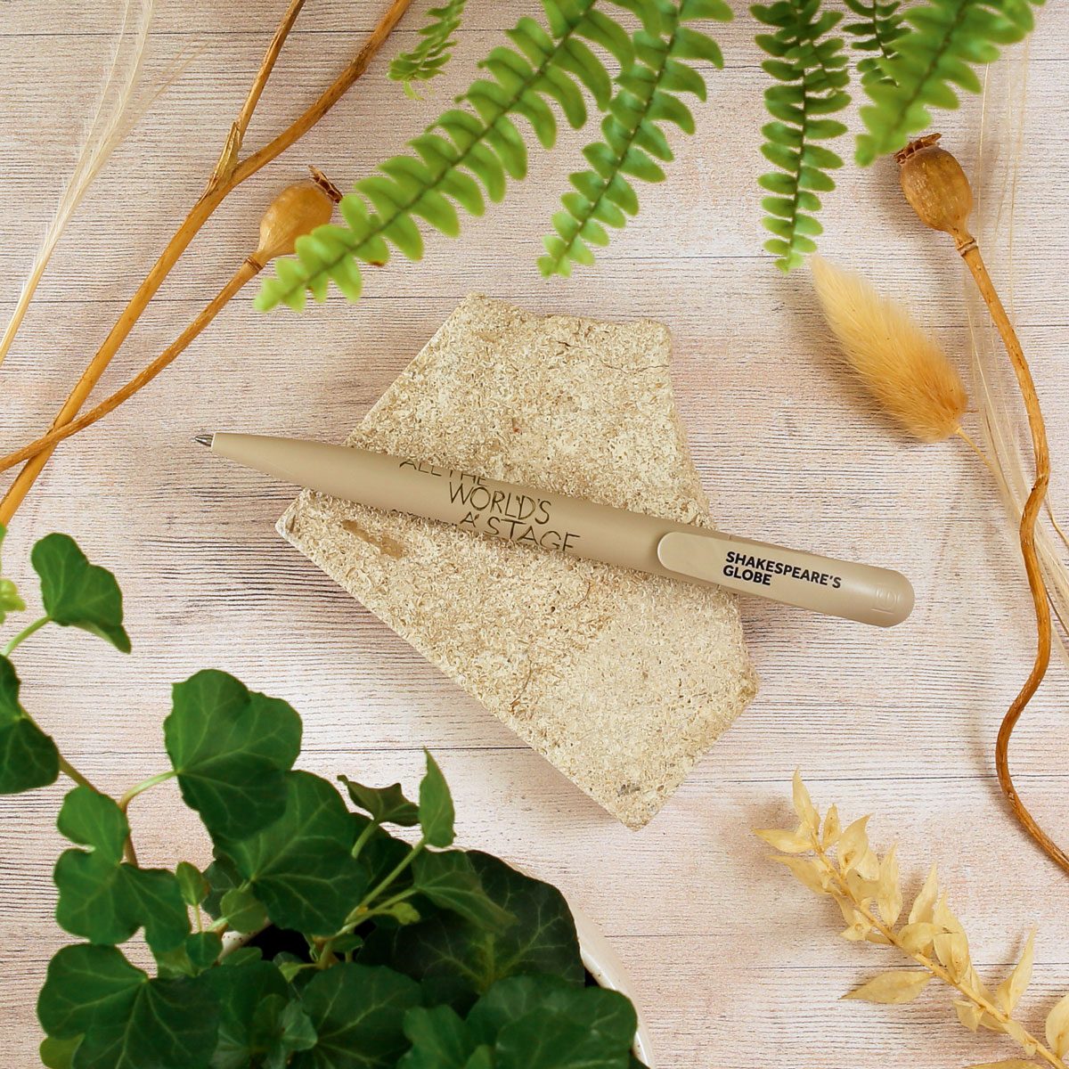 A beige bioplastic pen that reads 'All the world's a stage'.