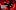 Much Ado About Nothing. Two people, so close they're almost touching each other, lie on a red floor covered in glitter and heart-shaped balloons. The image is seen from upside down.